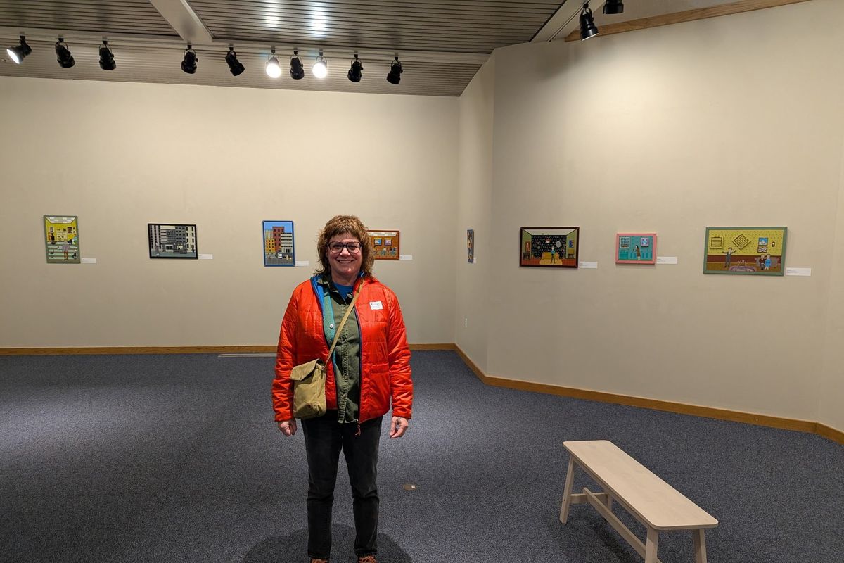 Artist Kristin Robbins stands in the Chase Gallery among her whimsical paintings and mixed media work.  (Courtesy of Kristin Robbins)