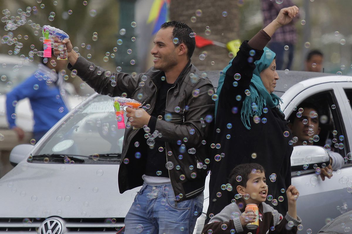 Gadhafi supporters celebrate in Tripoli, Libya, on Tuesday following a televised announcement that Moammar Gadhafi’s forces took Ajdabiya. (Associated Press)