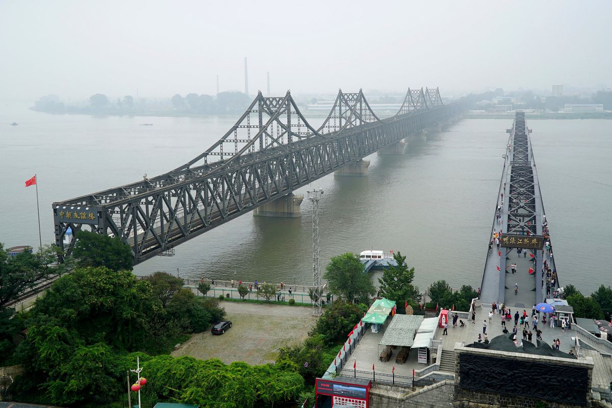 FILE - Visitors walk across the Yalu River Broken Bridge, right, next to the Friendship Bridge connecting China and North Korea in Dandong in northeastern China