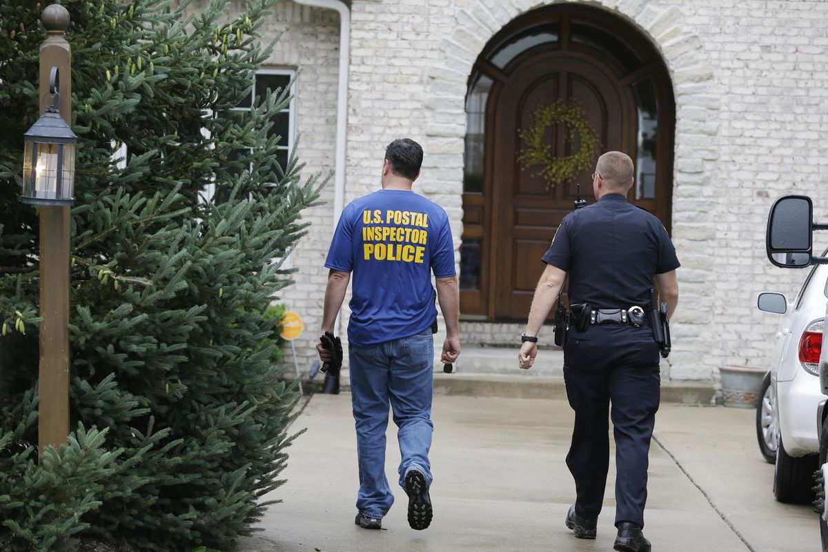 Federal authorities and a Zionsville police office arrive at the home of Subway restaurant spokesman Jared Fogle Tuesday, July 7, 2015, in Zionsville, Ind. FBI agents and Indiana State Police have removed electronics from the property. FBI Special agent Wendy Osborne said Tuesday that the FBI was conducting an investigation in the Zionsville area but wouldn