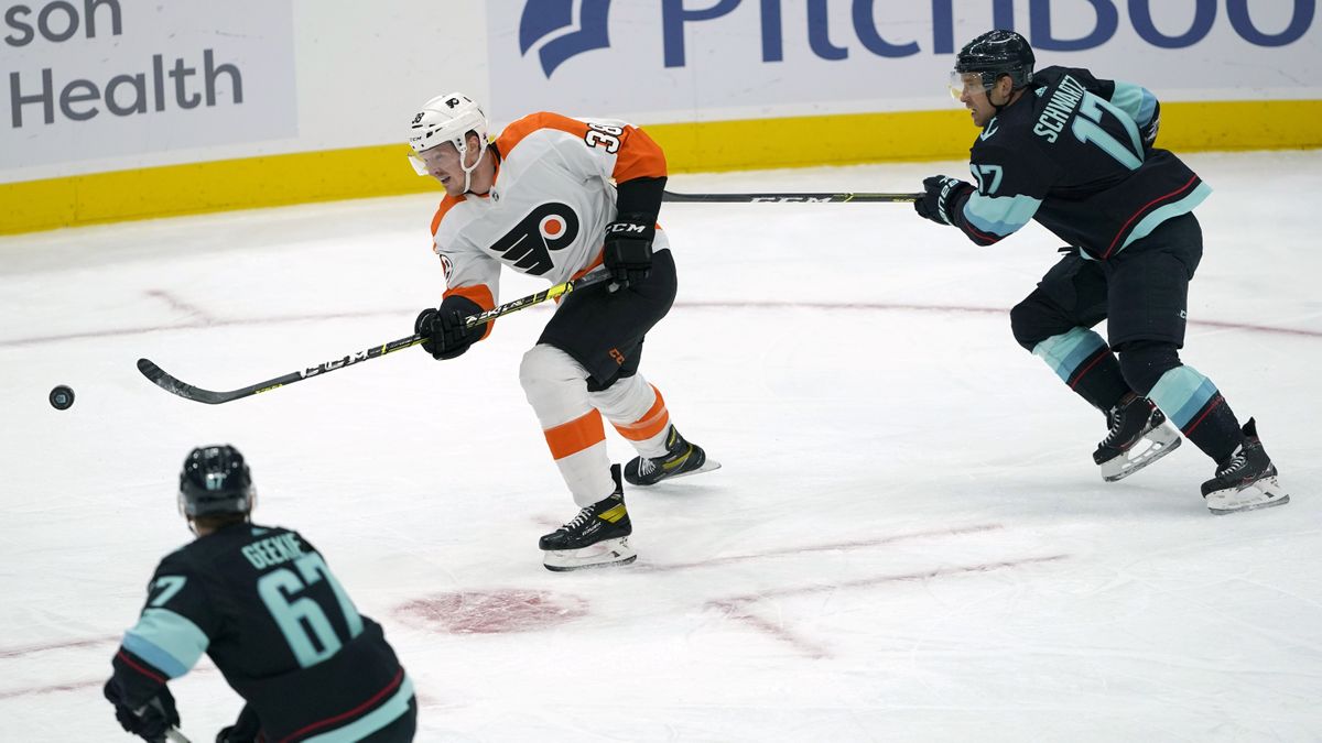 Philadelphia Flyers center Patrick Brown passes the puck ahead as Seattle Kraken center Jaden Schwartz (17) defends during the first period of an NHL hockey game Wednesday, Dec. 29, 2021, in Seattle.  (Ted S. Warren)
