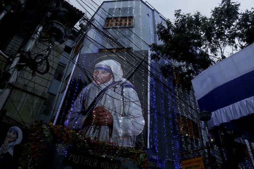 Mother House of the Missionaries of Charity group founded by Mother Teresa is illuminated with a huge portrait of her displayed in Kolkata, India, Sunday, Sept. 4, 2016. Pope Francis declared Mother Teresa a saint on Sunday, praising the tiny nun for having taken in society's most unwanted and for having shamed world leaders for the 
