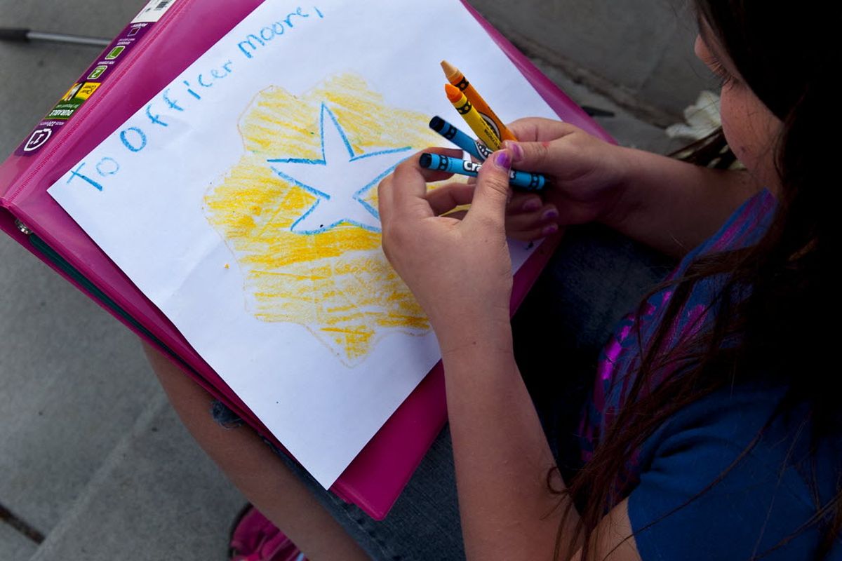 Nine-year-old Alissa Manuel of Newman Lake drew a picture for Sgt. Greg Moore during a gathering at McEuen Park in Coeur d