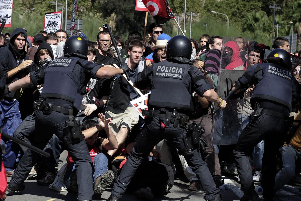  Riot police hit demonstrators during worker protests in Barcelona, Spain, Wednesday.  (Associated Press)