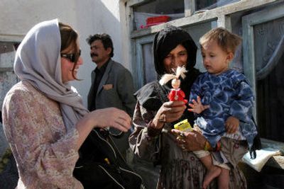 
American Susan Retik, left, gives a toy to an Afghan girl in Kabul on Thursday. Retik, whose husband was killed in the Sept. 11 attacks, is using the financial support she received to help Afghan widows. 
 (Associated Press / The Spokesman-Review)