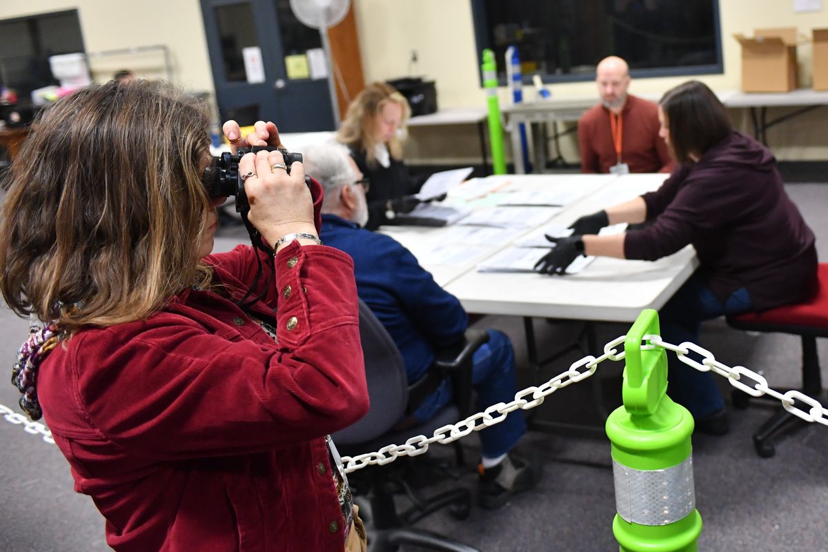 Teresa Hudson, who said she is with the GOP, uses a pair of binoculars to survey the scene during a hand recount of votes for the Spokane County auditor’s race on Wednesday at the Spokane Elections Office.  (Tyler Tjomsland/The Spokesman-Review)