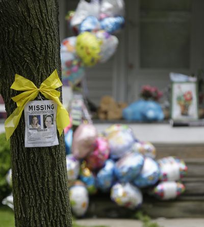 A missing poster still hangs on a tree Saturday at the home where Amanda Berry is staying in Cleveland. The porch continues to fill with gifts, flowers and balloons. (Associated Press)