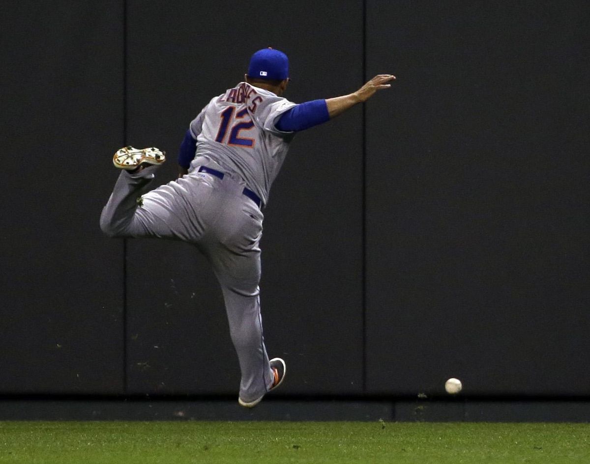 Mets center fielder Juan Lagares chases down a triple hit by Royals’ Alcides Escobar in the eighth inning. (David J. Phillip / Associated Press)