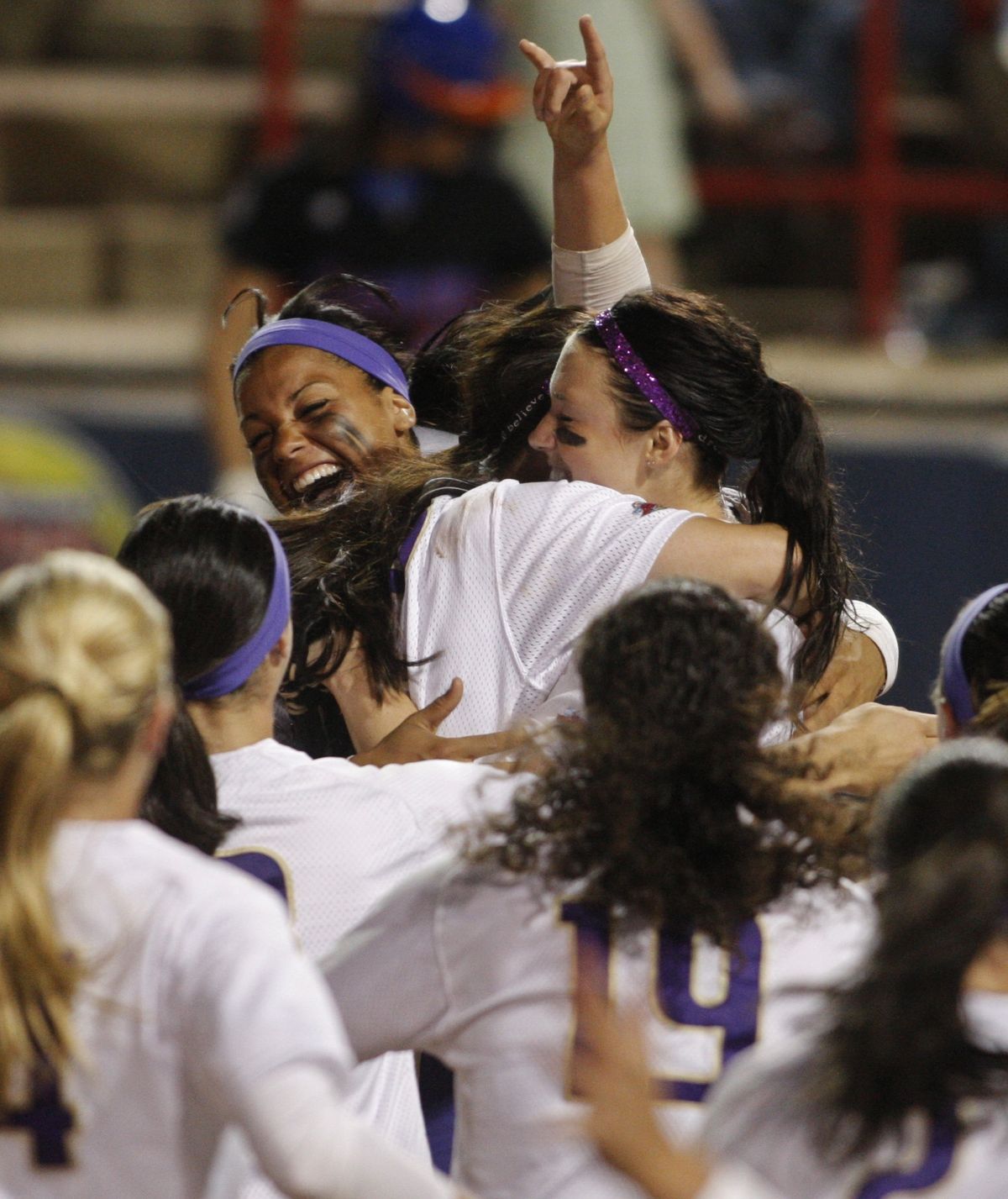 Washington’s Niki Williams, top left, Alicia Blake, center, and Danielle Lawrie are mobbed by teammates at home plate as Washington defeats Florida 3-2 for the NCAA softball title. (Associated Press / The Spokesman-Review)