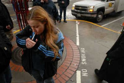 Melissa Long stops for a quick smoke inside a lined-off smoking area at the STA Plaza on Tuesday. Sometimes as many as 40 smokers cram into the small designated smoking area outside of the plaza.
(Jesse Tinsley / The Spokesman-Review)