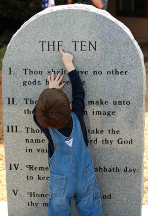 Nate Shepherd, 2, uses his finger to trace chiseled letters on the monument after a ceremony in Poteau, Okla., Wednesday, Jan. 20, 2010. Shepherd is grandson of former Poteau Mayor Don Barnes, who started the effort to place the Ten Commandments marker in the town. About 200 people attended the unveiling and dedication of a new monument with the Ten Commandments etched into its granite surface on the front lawn of the Community State Bank. (Jim Beckel / The Oklahoman)