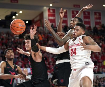 Houston’s Breaon Brady (24) reaches for a rebound along with Southern Methodist’s Isiaha Mike, center, and Ethan Chargois, left, during the first half of an NCAA college basketball game Thursday, March 7, 2019, in Houston. (David J. Phillip / Associated Press)