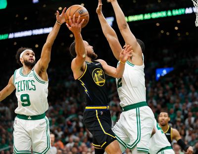 Golden State’s Stephen Curry shoots against Boston’s Derrick White (9) and Grant Williams during the first quarter of Game 3 of the NBA Finals in Boston on Wednesday.  (Nhat V. Meyer/Tribune News Service)