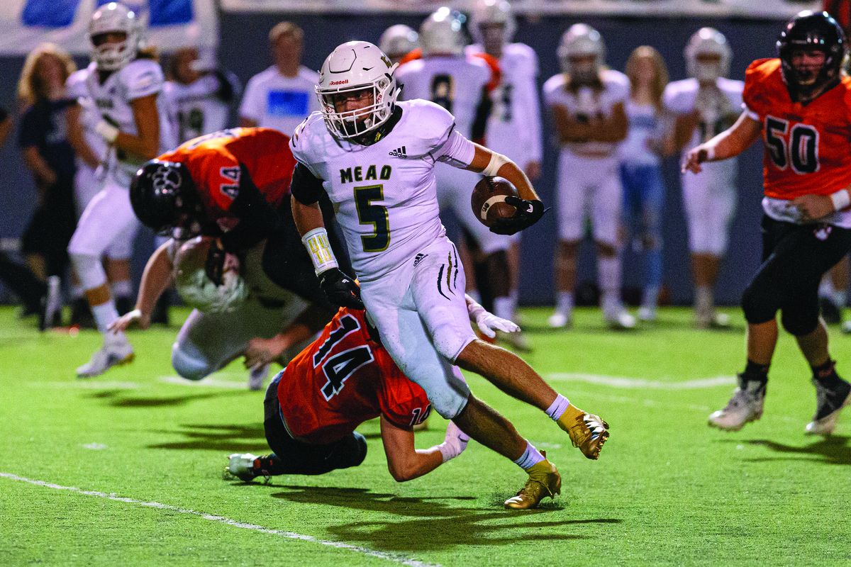 Mead running back Caleb Shawen (5) breaks a tackle against Lewis and Clark on Thursday, Sept. 19, 2019, at Joe Albi Stadium in Spokane, Wash. (Cheryl Nichols/For The Spokesman-Review)