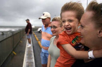 
Wilson Hardin, 3, of Abilene, Texas, reacts to the strong wind as his grandmother Debra Hanes holds him while they watch surfers in Galveston on Wednesday. Houston Chronicle
 (Sharon Steinmann Houston Chronicle / The Spokesman-Review)