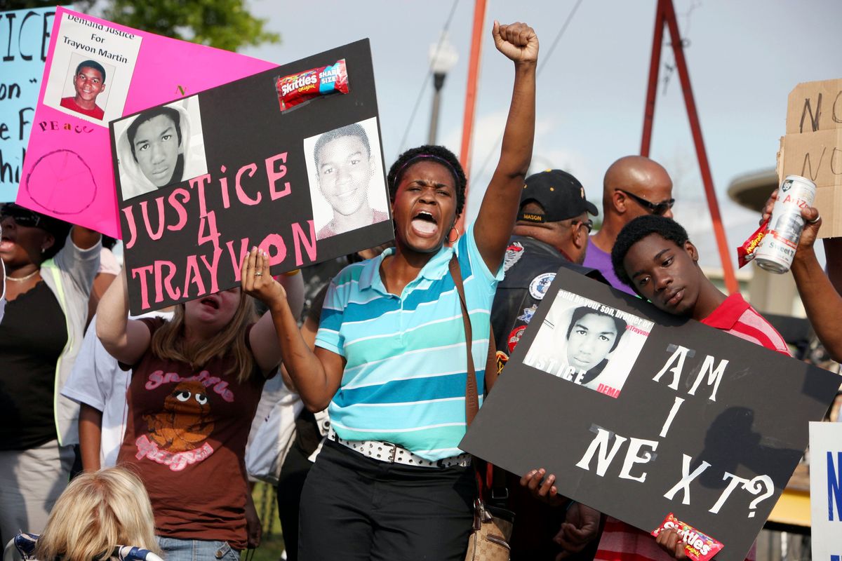 Protestors, Lakesha Hall, of Sanford, center, and her son, Calvin Simms, right, participate in a rally for Trayvon Martin, the black teenager who was fatally shot by George Zimmerman, a neighborhood watch captain in March 2012 in Sanford, Fla.  (Julie Fletcher)