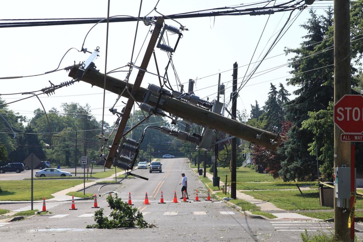 A broken section of a utility pole dangles from cables on Saturday, June 30, 2012 after a fast moving storm caused power outages in southern New Jersey.  ( Vernon Ogrodnek/Associated Press/The Press of Atlantic City)