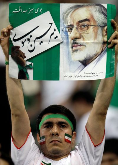 An Iranian soccer fan holds a poster with the image of Iranian opposition leader Mir Hossein Mousavi at a match in Seoul, South Korea, on Wednesday.  (Associated Press / The Spokesman-Review)