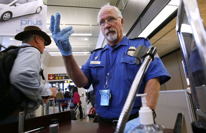 TSA officer Robert Howard signals an airline passenger forward at a security check-point at Seattle-Tacoma International Airport, Monday, Jan. 4, 2010, in SeaTac, Wash. The names of dozens more people have been added to the government's terrorist watch list and no-fly list after a failed terrorist attack on Christmas prompted U.S. officials to closely scrutinize a large database of suspected terrorists, an intelligence officials said. (Elaine Thompson / Associated Press)