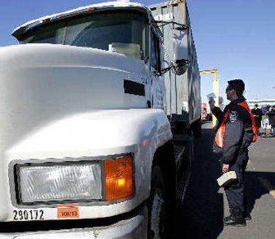 
A U.S. Customs and Border Protection officer checks a trucker's paperwork at the port of Newark, N.J. Cargo industry officials are worried that a federal ID system aimed at boosting security could cost many port workers their jobs, something that would bottle up the flow of goods destined for virtually every U.S. community. 
 (Associated Press / The Spokesman-Review)