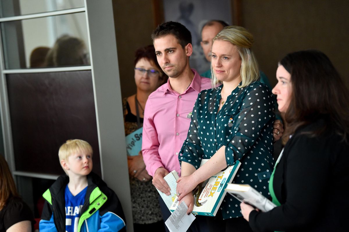 Laura Brincken and her husband Cody, parents of Isaac Brincken, who at 5-months-old died from complications of a heart condition and CHARGE syndrome, listen as “Isaac’s Bookshelf” is dedicated in his honor on Monday at Sacred Heart Children’s Hospital in Spokane. Isaac’s Bookshelf was created in his memory to share the joy of reading with children who are in the hospital undergoing treatment for complex medical conditions. The bookshelf rolls around the unit visiting patients. (Tyler Tjomsland / The Spokesman-Review)