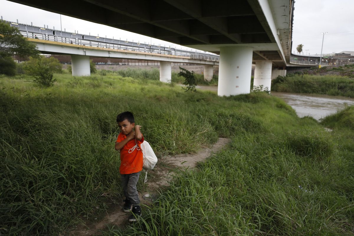 Hassan Bustio Paz, a 5-year-old from Honduras, walks with his mother and other migrants below Puerta Mexico bridge that crosses the Rio Grande in Matamoros, Tamaulipas state, Mexico, Wednesday, June 26, 2019. Hassan’s mother said she is one of at least four migrants who were told they could not put their names on the monthslong list to request asylum in the U.S. at this border post, since they did not request Mexican papers after crossing the southern border. (Rebecca Blackwell / Associated Press)