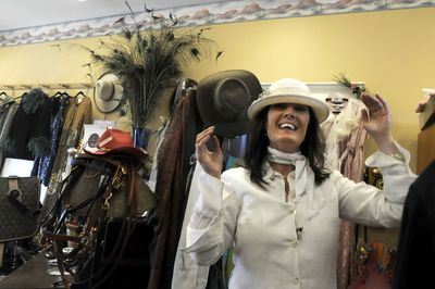 Christine Brouillette tries on a hat in her shop, The Emporium, last week, in a space in Cheney owned by Natasha Jernegan, who has renovated an old car wash into a strip of small shops. Brouillette’s shop carries vintage clothes, Western wear, antiques and lots of hats. (Jesse Tinsley / The Spokesman-Review)