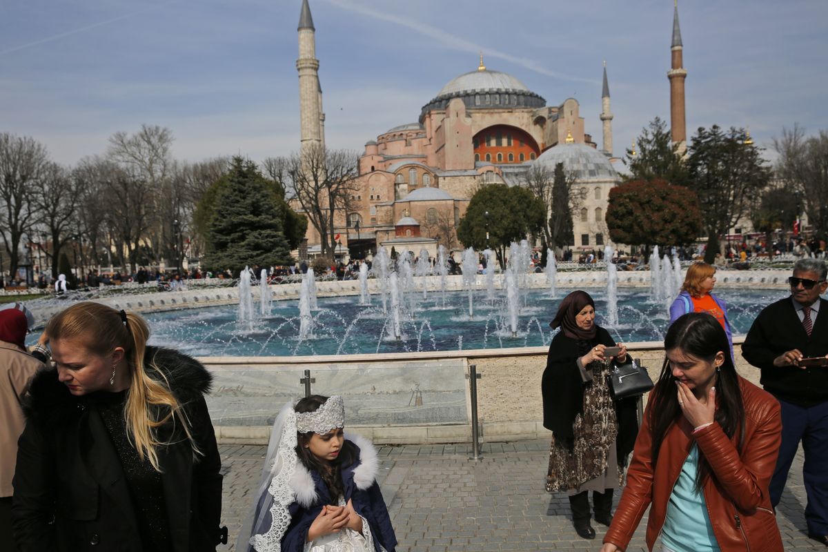 FILE - In this Friday, March 24, 2017 file photo, people walk backdropped by the Byzantine-era Hagia Sophia, one of Istanbul