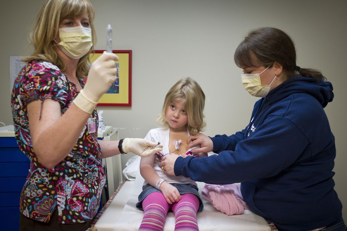 Cancer patient Madeline Cumbie, 4, and her mom, Jenny Cumbie, know the procedure well as they watch nurse Margaret Duarte access her medical port to draw labs. Madeline was diagnosed with acute lymphoblastic leukemia in April 2010. (Colin Mulvany)