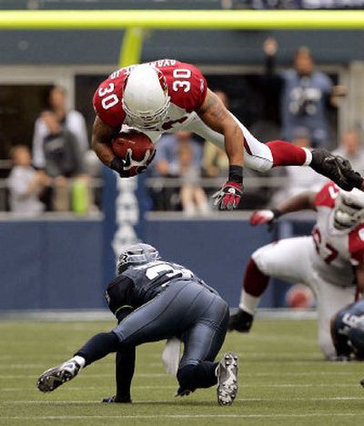 
Arizona's Obafemi Ayanbadejo (30) leaps over Seattle's Kelly Herndon as he gains additional yards on a 13 yard pass-play. 
 (Associated Press / The Spokesman-Review)