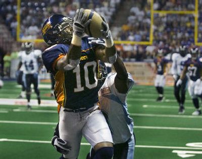 
Charles Frederick of the  Shock leaps to catch a touchdown pass from quarterback Kyle Rowley as Delenell Reid of Arkansas defends Saturday at the Arena.  
 (Christopher Anderson / The Spokesman-Review)