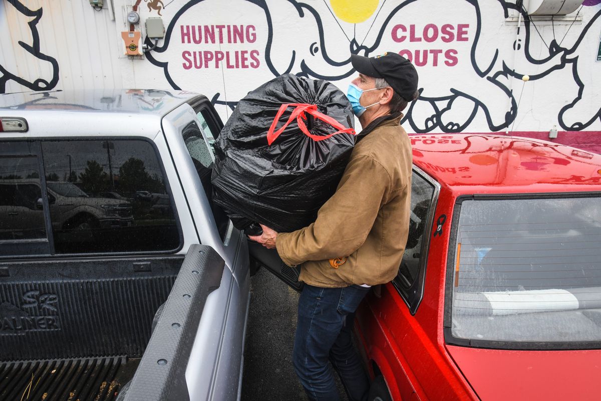 John Respold squeezes a bag of toys for his grand kids and camping supplies into his truck after shopping the White Elephant liquidation sale, Tuesday, June 9, 2020, on Division Street in Spokane, Wash. Dan Pelle/THE SPOKESMAN-REVIEW  (DAN PELLE)
