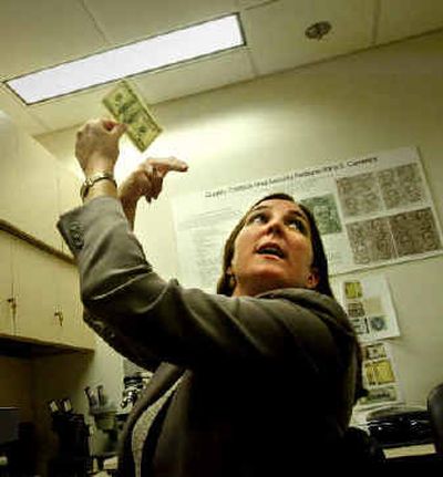 
Lorelei W. Pagano, a counterfeit specialist with the U.S. Secret Service, talks about recognizing counterfeit cash in the Secret Service anti-counterfeiting lab.
 (Associated Press / The Spokesman-Review)