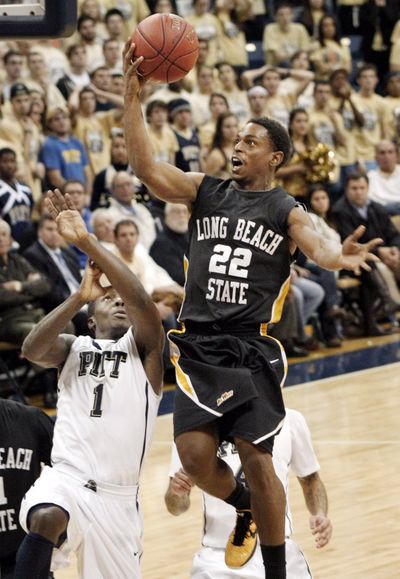 Long Beach State’s Casper Ware scores over Pittsburgh’s Tray Woodall during the second half Wednesday. (Associated Press)