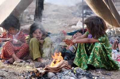 
Kashmiri children living in a tented village warm themselves by a morning fire in Muzaffarabad, Pakistan, Wednesday. 
 (Associated Press / The Spokesman-Review)