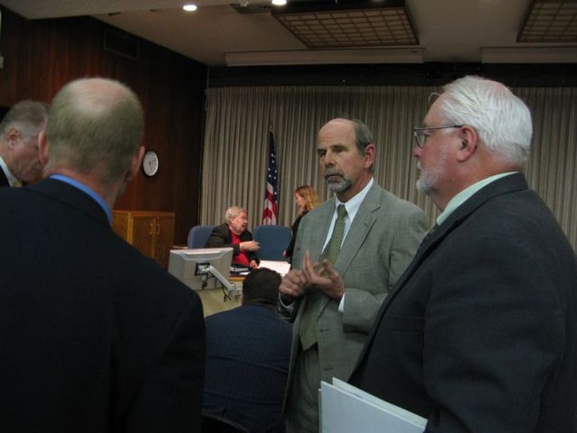 Lawyers from all sides, including Laird Lucas, second from right, of Advocates for the West, and Larry Allen, right, of the Idaho Transportation Department, confer after the close of testimony Wednesday in the Highway 12 megaloads contested-case hearing; in the background is the hearing officer, retired Idaho District Judge Duff McKee. (Betsy Russell)