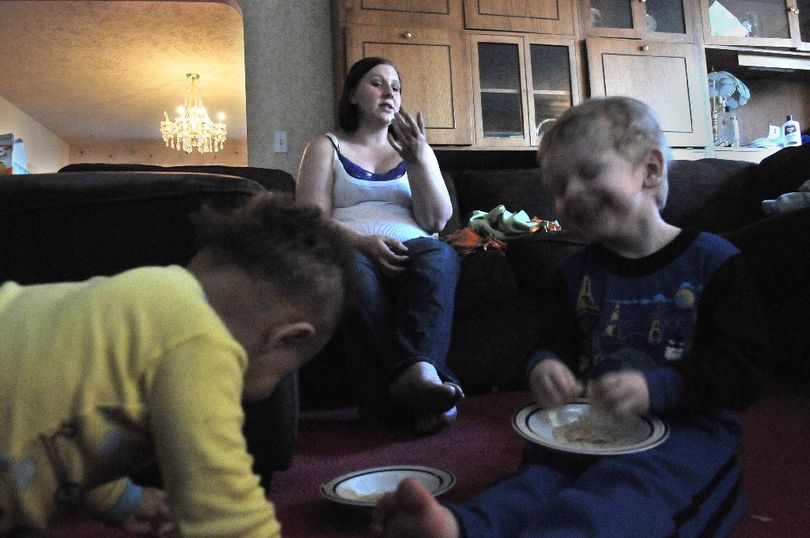 Michonda Weaver, center, talks about her boyfriend and waits for word of what happened to  Leighton  Welch, while two of her children Elijah, left, and Zackahriha (cq) have a snack in their South Hill apartment Tuesday, April 6, 2011. Weaver said she was talking to  Leighton  Welch on the phone a week ago when it sounded like he fell or dropped the phone and that was the last she has heard of him. Two of her three children are his and she can't conceive of why he would disappear like he has.  (JESSE TINSLEY jesset@spokesman.com)