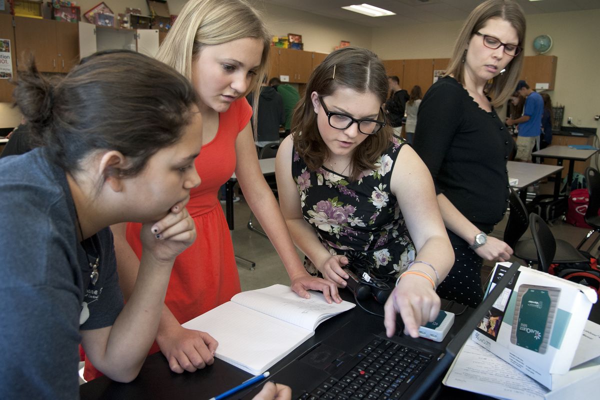 Ferris High biomed teacher Darci Hastings, right, keeps an eye on, from left, Allison Wagner, Sarah Sherfey and Shaylynn Sapp as they work with a heart monitor Thursday. Ferris is being held up as a statewide example for its success rate in a mandated biology exam. (Dan Pelle)