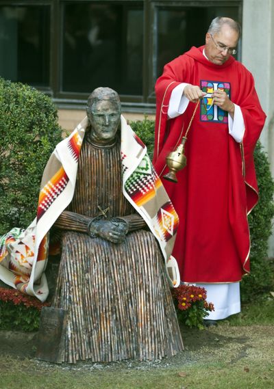 A statue of Father Cataldo is blessed by the Rev. Tom Lankenau at Gonzaga Prep on Sept. 21. (Colin Mulvany)