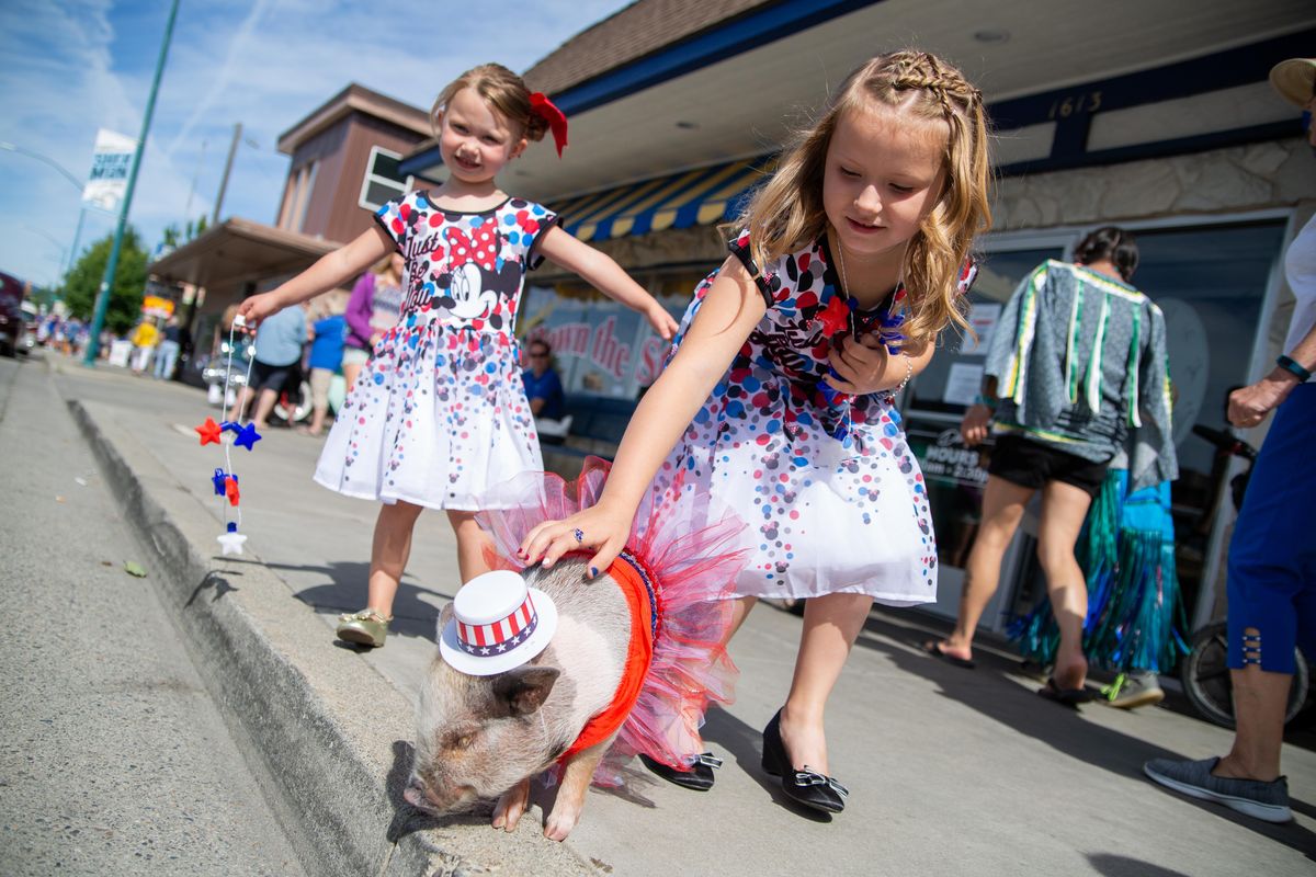 Ashley Saint, 4, and Brookyln Wiedler, 8, pet Angel the micro pig on the morning of July 4, 2018. Angel’s owner Karen Whaley was also in attendance for the annual Fourth of July parade in Couer d’Alene. (Libby Kamrowski / The Spokesman-Review)