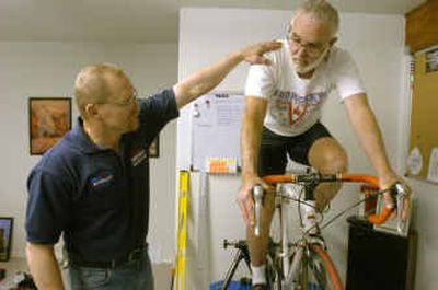 Technician Jim Kozak, left, talks with cyclist Rusty Baillie about the fit of his bike to his body while Baillie pedals in a training stand.
(Jesse Tinsley / The Spokesman-Review)