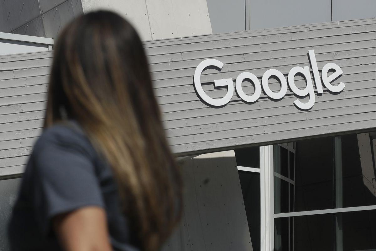 A woman walks below a Google sign on the campus in Mountain View, Calif., on Sept. 24, 2019. Lawmakers are getting creative as they introduce a slew of bills intended to take Big Tech down a peg and the proposed legislation targeting personal data collected from young people could hit the bottom line of the social media companies.  (Jeff Chiu)