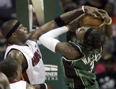 Miami’s Jermaine O’Neal blocks a shot by Charlotte’s Gerald Wallace Friday during the Heat’s playoff-clinching win at Charlotte, N.C.  (Associated Press / The Spokesman-Review)