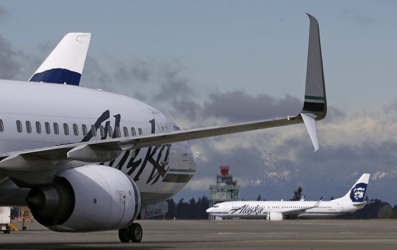 Alaska Airlines planes wait for takeoff, Monday at Seattle-Tacoma International Airport in Seattle. Alaska Airlines parent company announced Monday that it will pay $2.6 billion to buy the Richard Branson-inspired, California-based Virgin America. (AP Photo/Ted S. Warren)