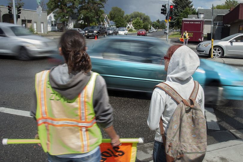 Longfellow Elementary School crossing guard LaCrisha Loper stands with students before assisting them across Nevada at Empire, June 14, 2016, in Spokane, Wash. The school zone speed camera program has issued 4,248 tickets in the Nevada zone between Jan. 1 and May 31, 2016. (Dan Pelle)