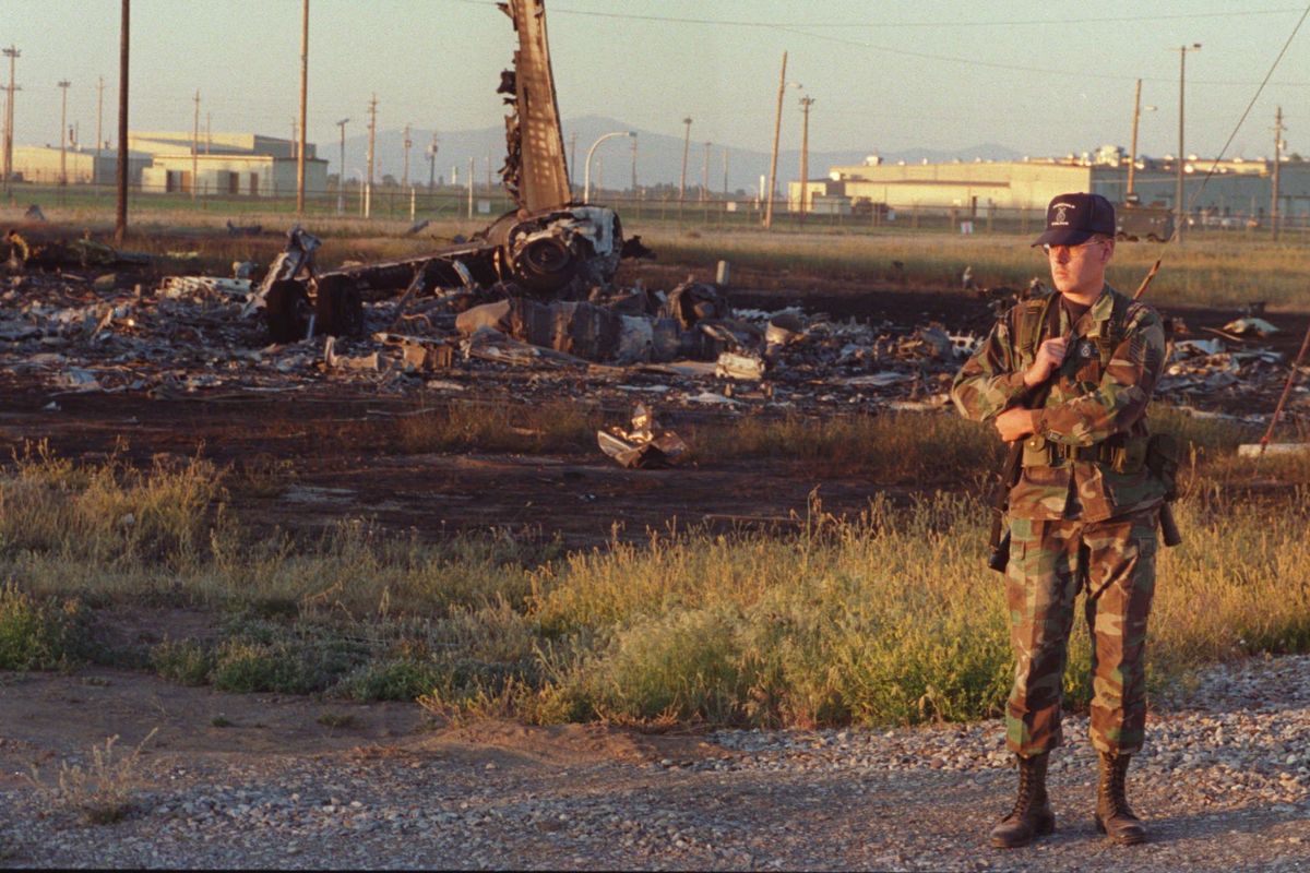 A Fairchild Air Force policeman stands guard over the wreckage of the B-52 on Friday night, June 24, 1994. The B-52 crashed Friday afternoon south of the main runway on Fairchild AFBase while practicing maneuvers for as air show. (SR / SPOKANE)