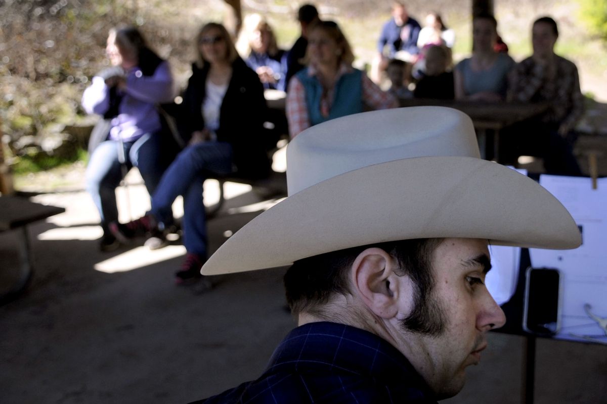 Nathan Smith, of Spokane, plays the guitar during the Easter on horseback service at the Bowl and Pitcher on Sunday. About 20 horses and riders and another 10 people on foot participated in the event organized by Teresa York, who has always wanted to ride her horse to church. (Kathy Plonka)