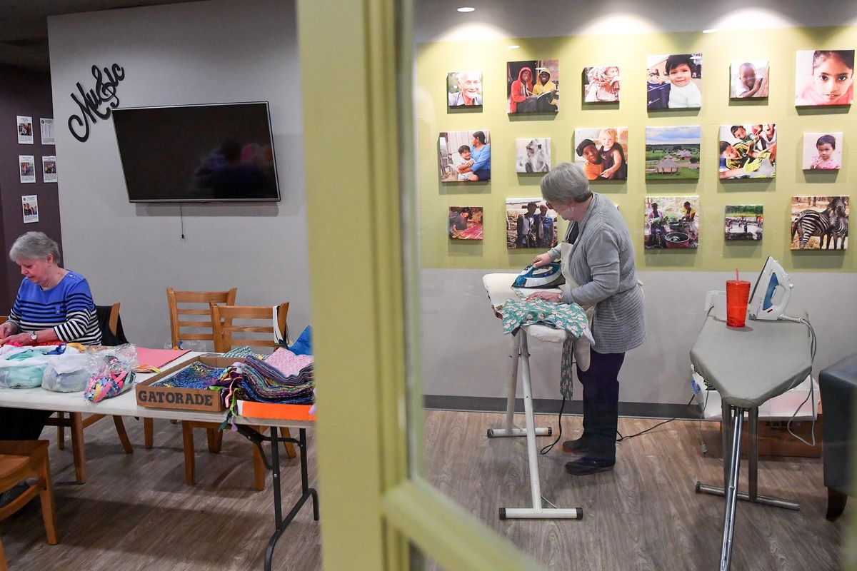 Beverly Offield, left, puts drawstrings on bags as Gerry Kittel, right, irons them as they create feminine hygiene kits for Days For Girls on June 8 at Garland Church in Spokane, Wash. Days For Girls is an international organization that provides reusable, sustainable sanitary supplies to young women in third world countries, primarily in Africa. (Tyler Tjomsland / The Spokesman-Review)