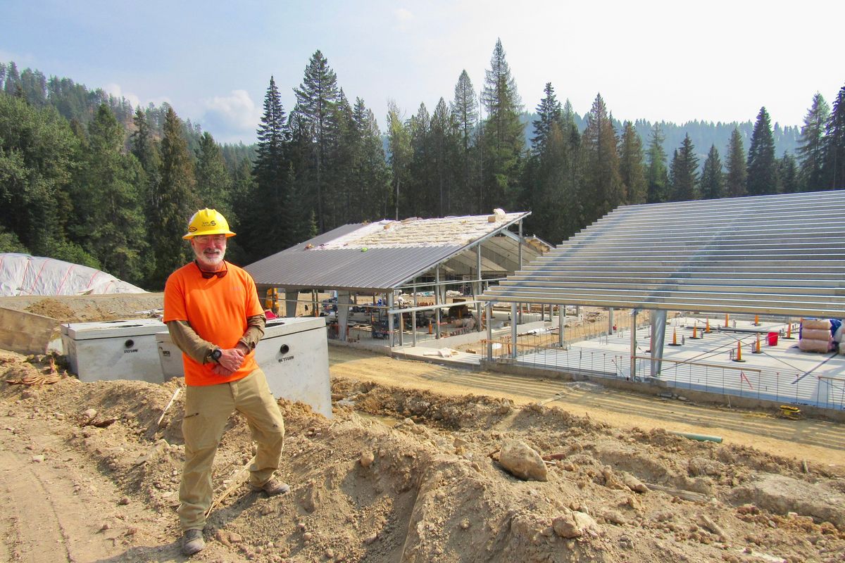 Seattle City Light fish biologist and project manger Harry Rich is standing in front of the two main fish hatchery buildings nearing completion 7 miles from Usk.  (The Spokesman Review)