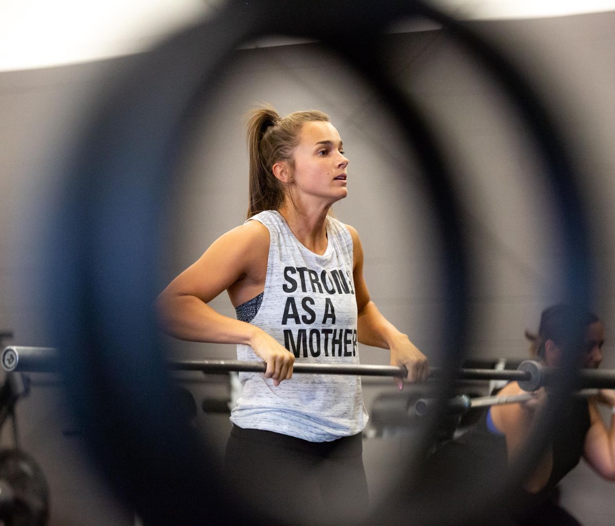 Andrea Bickley faces a mirror while executing a warmup exercise at Farmgirlfit in Spokane on the morning of Aug. 17, 2018. Roughly 20 women attended a morning crossfit class that included a rigorous regimen of six front squats with weight, eight burpees, 30 unbroken kettle bell swings and 40 "DU